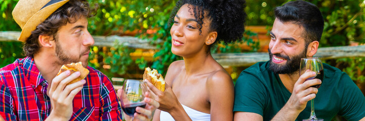 Fototapeta premium Group friends having picnic at park – people haging out – group friends having picnic on backyard – happy friends in park having picnic together - banner size for header design