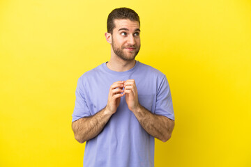 Handsome blonde man over isolated yellow background scheming something