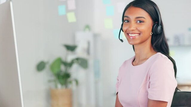 Portrait of call center agent with a headset to help customers online while working on a desktop computer in an office alone at work. Female helpdesk worker talking and communicating with clients
