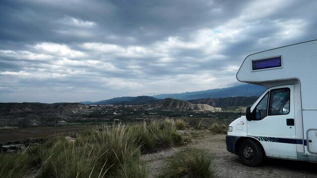 Time lapse of clouds moving over caravan camping on Tabernas desert landscape in Almeria, Spain. Movie location set for spaghetti western.