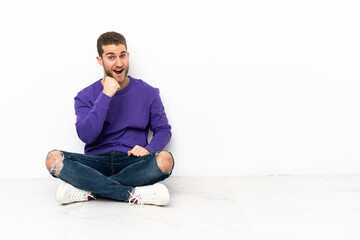 Young man sitting on the floor celebrating a victory