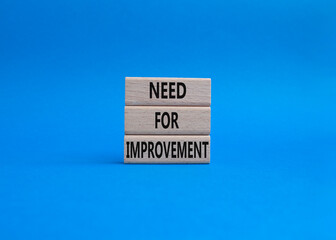 Need for Improvement symbol. Wooden blocks with words Need for Improvement. Beautiful blue background. Business and Need for Improvement concept. Copy space.