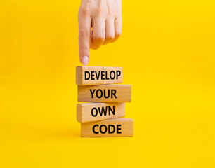 Develop your own code symbol. Concept words Develop your own code on wooden blocks. Beautiful yellow background. Business and Develop your own code concept. Copy space.