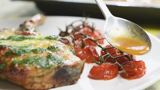 Pork Chop With Cherry Tomatoes And Mozzarella. Pouring Sauce On A Cherry Tomatoes.
