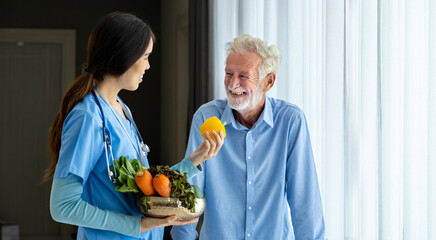 Hospice nurse and nutritionist is suggesting variety of vegetable to Caucasian man at pension retirement center for home care rehabilitation and post treatment recovery process