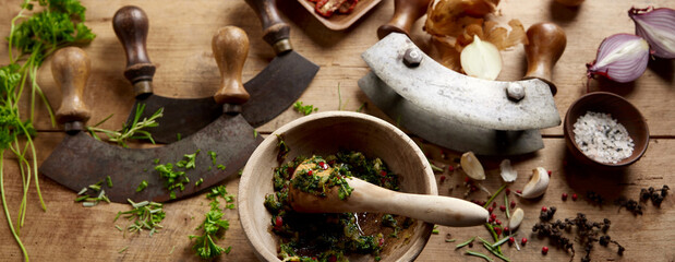 Mortar and pestle with greens on table