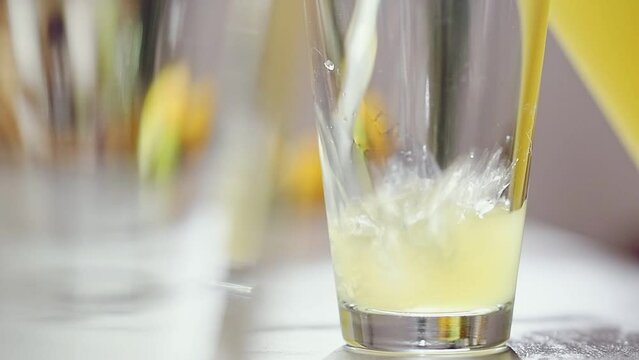 Ginger lemonade is poured into a transparent glass.
