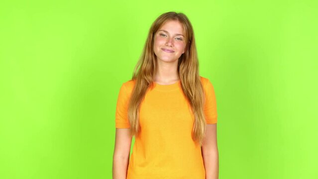 Young pretty blonde woman on green screen chroma key with happy face over isolated background