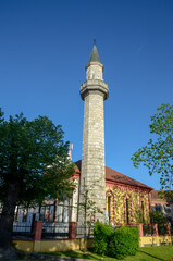 Old stone minaret and mosque. Symbol of Islam. Mosque in Velika Kladuša, Bosnia and Herzegovina. 