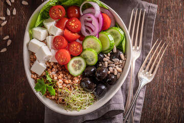 Colorful Greek salad with cheese, olives, cucumber and tomatoes.