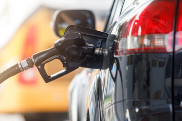 Refuel the car.Fuel nozzle. Higher oil prices.Refueling the car at a gas station fuel pump. Man...