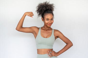 Happy beautiful young african woman wearing sportswear showing arms muscles smiling with confident and proud on white background. fitness concept.