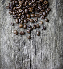 picture of coffee beans stacked on wooden floor on a dark background with copy space