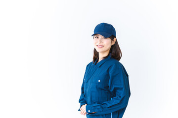 作業服を来て笑顔で仕事をする若い女性