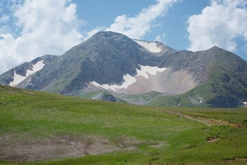 Fototapeta premium Summer mountain landscape with places of lying snow that has not lost.