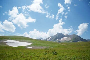 Obraz premium Summer mountain landscape. High mountains and above the mountains a bright blue sky