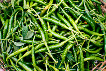 Fresh chili peppers from the chili garden are heaped in bamboo baskets