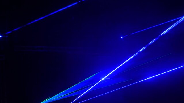 Light laser show on a black background of the night sky, outdoor performance. Multi-colored laser beams turn into various shapes, projection on smoke. Information Technology Conference