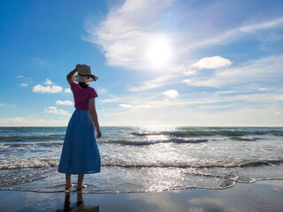 woman looks at sunset beach