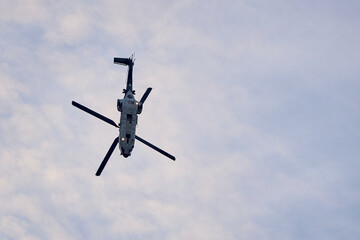 The helicopter flies down against the blue sky. Rescue operation.