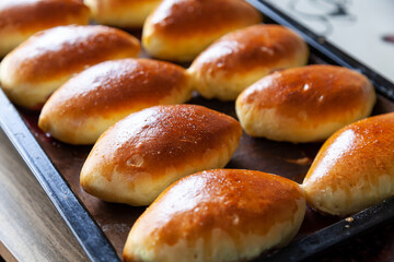 Russian meat piroshki. Traditional hand mini pies on wooden background. Rustic style, closeup view. Russian traditional patties usually made by grandmothers