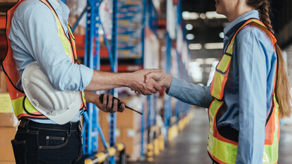 Warehouse Worker Handshake for partnership in logistic center, Industrial worker talking and deal for business in storehouse. Working in Storage Distribution Center.