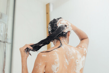 Naklejka premium Woman Washing hair with shampoo and shower in bathroom, Asian female body and hair care with foam to freshness. Spa and Health care.