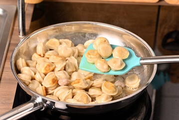 Fried dumplings in a frying pan.