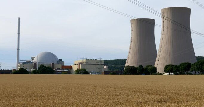Grohnde, Germany - 07/12/2022; Nuclear power plant reactor and cooling towers. Embedded in landscape with trees, fields and forest.