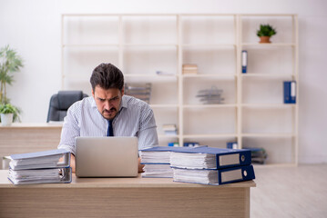 Fototapeta premium Young male employee and too much work in the office