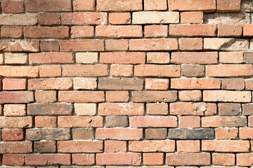 old brick wall in orange color with empty seams