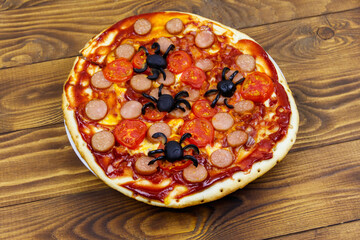 Halloween pizza with spiders on wooden table