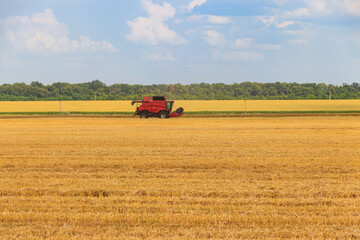 Fototapeta na wymiar Combine harvester working on a wheat field. Harvesting the wheat. Agriculture concept
