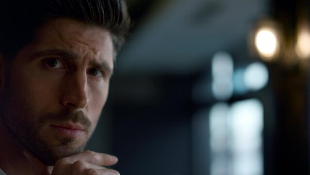 Businessman thinking in dark cafe portrait. Pensive man face expression closeup