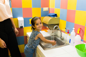 Cute kid going to the bathroom and washing her hands