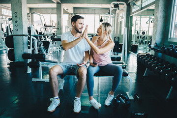 Naklejka na ściany i meble Smart sport man and woman working out in fitness gym