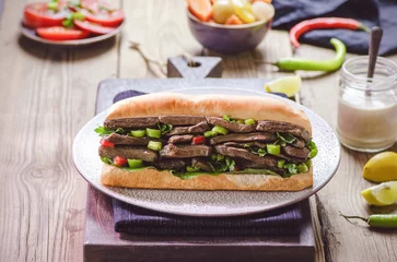Papier Peint photo Snack Arabic cuisine  Egyptian traditional liver sandwich or "Alexandrian liver sandwich". Served with tahini sauce, pickles, tomato slices with garlic and fresh parsley.