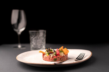 plate with delicious tuna tartar with glass on the backround