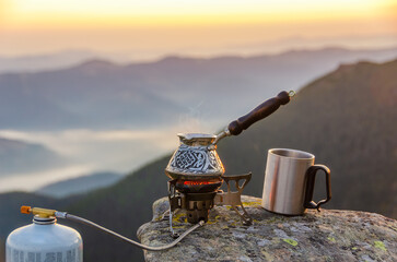 Coffee on the top of the mountain. Boilling coffee pot on a stone with amazing mountain view.