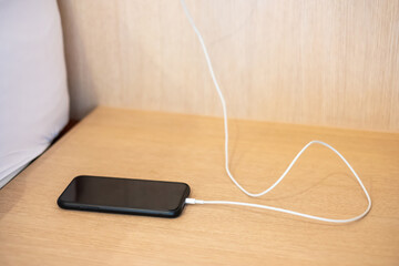 mobile smartphone charging battery on table at home or office. Technology, multiple sharing and recharge concepts