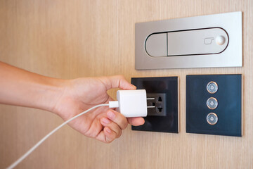Closeup finger unplugging or plugging of electricity device at home. Energy Saving, power,...
