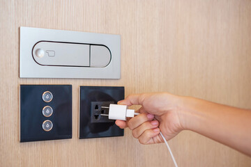 Closeup finger unplugging or plugging of electricity device at home. Energy Saving, power,...