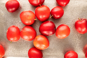 Several organic juicy cherry plums on a metal tray, close-up, top view.