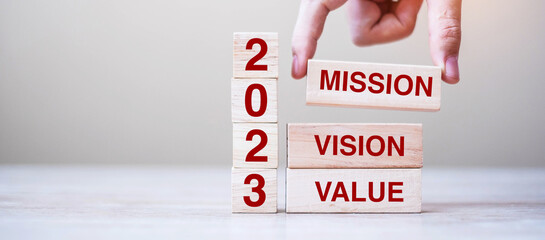 wooden block with text 2023 MISSION, VISION and VALUE on table background. Resolution, strategy,...