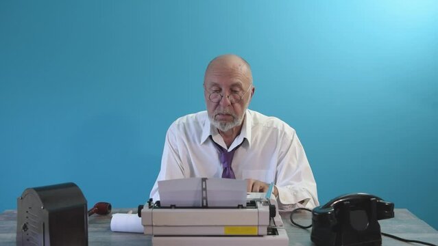 The author-journalist is typing on a typewriter. Table with telephone and typewriter. Writer editor. Vintage