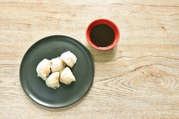Ha Kao or white dumpling stuffed shrimp and pork on plate dipping soy sauce