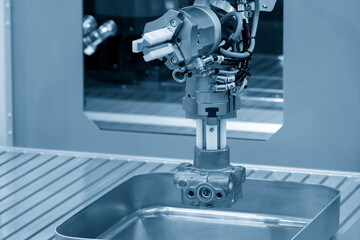 The automatic  robotic arm gripping the metal parts from CNC lathe machine.
