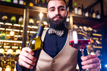 Authentic people happy successful male winemaker is tasting a flavor and checking red wine quality