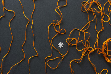 orange string with paper asterisk on dark gray board 