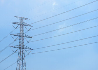 Bottom up view of high voltage electric post and electric cable with cloud and blue sky as background.